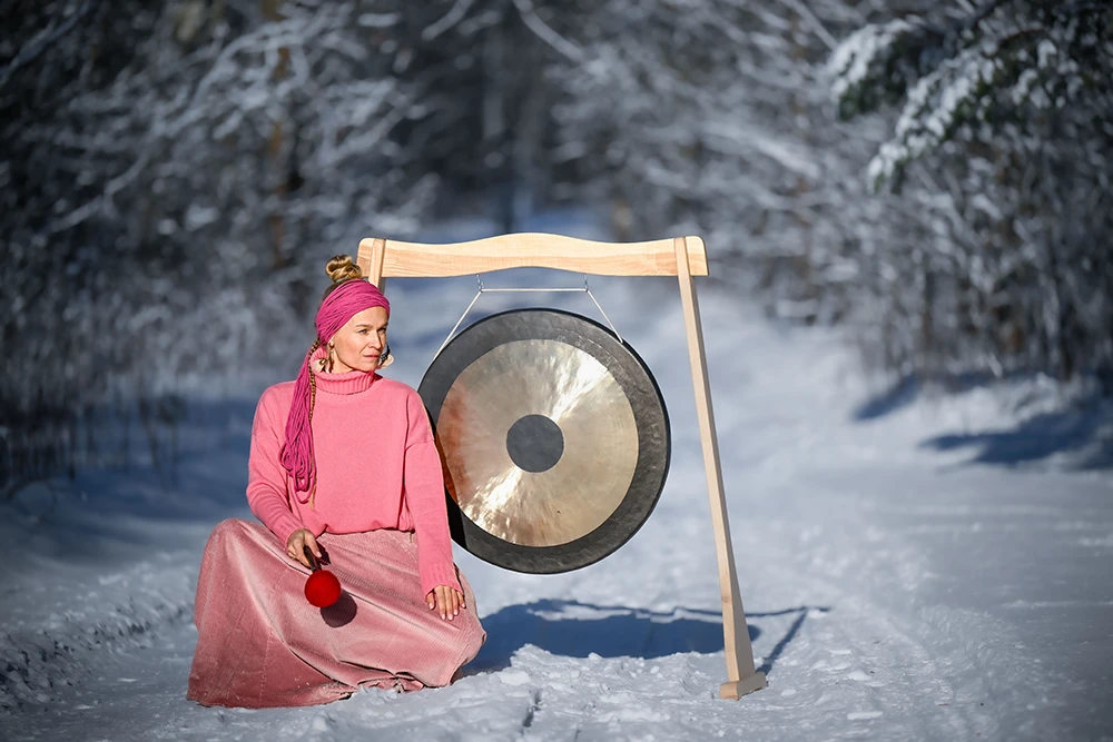 Patrycja Adaszewska w zimowej aurze, gra na gongu.